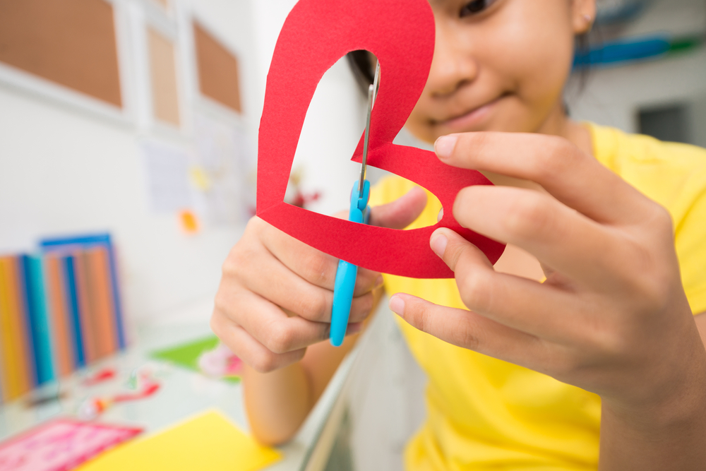 girl-cutting-paper-hearts