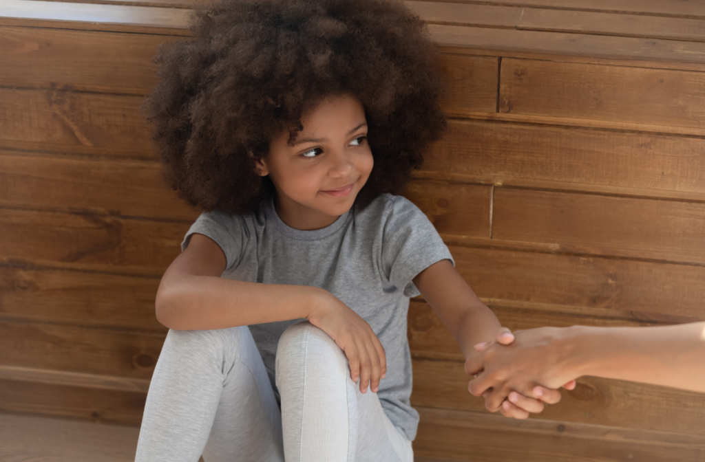 Smiling child holding hands with caring adult